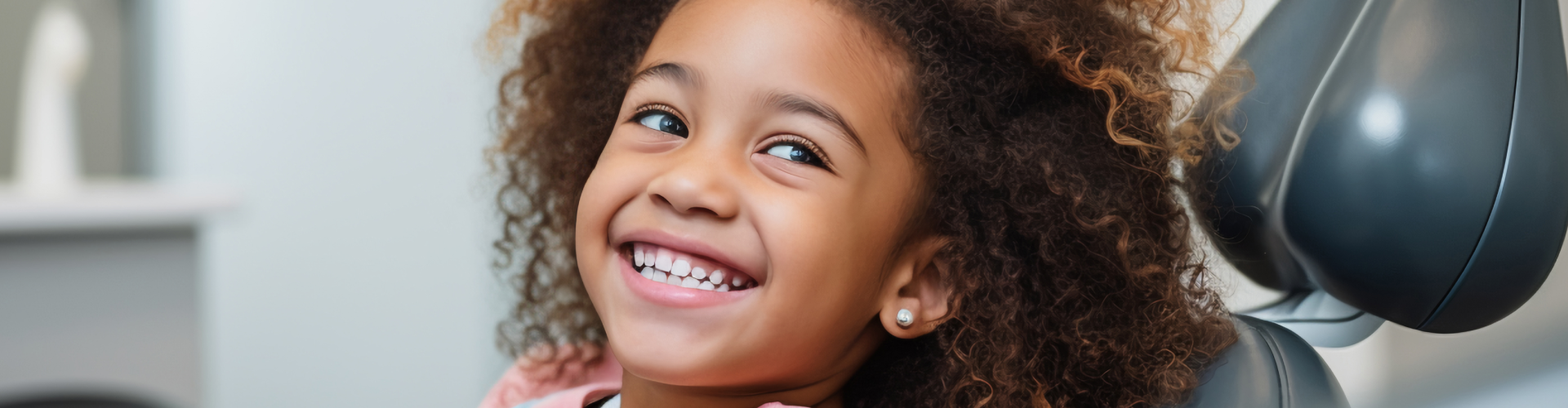 Face of smiling girl in dental chair.